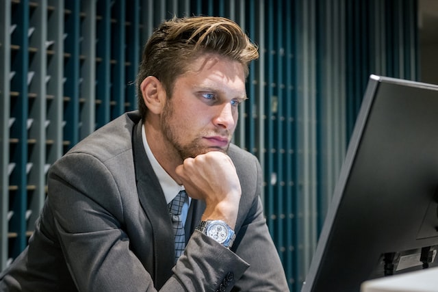 Male Receptionist looking at his Computer
