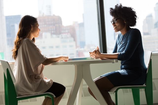 girls sit at a table and talk