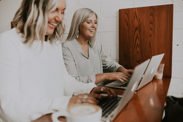 girls sit at the table and work