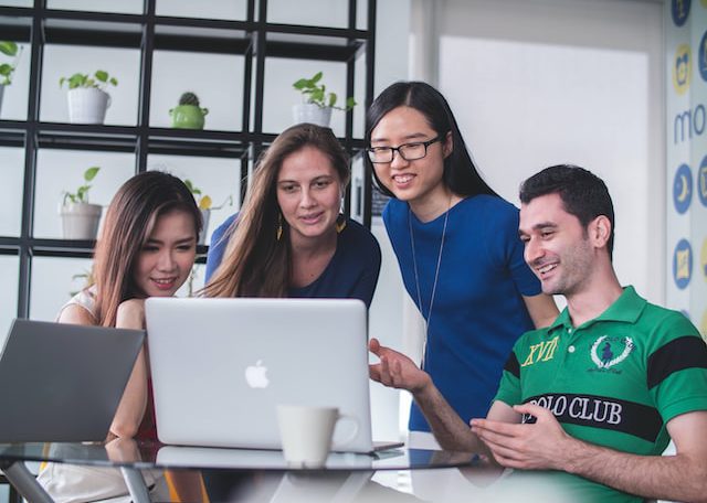 group of people looking at a laptop