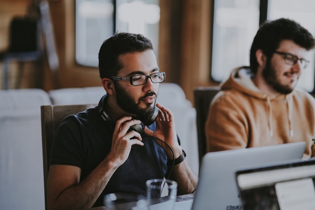 man sitting at the table in the office with headphones