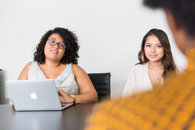 two girls look at a man