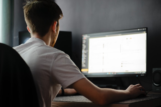 a-man-sitting-in-front-of-a-computer-monitor